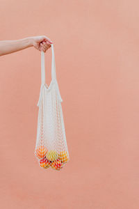 Midsection of woman hanging in basket against wall