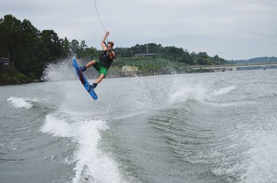 Man surfing in sea against sky