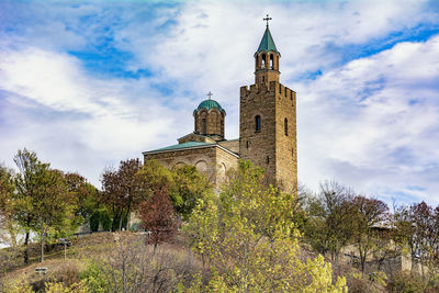 Low angle view of trees and building against sky