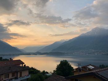 High angle view of townscape by lake against sky during sunset