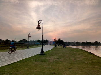 People on road against sky during sunset