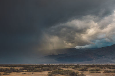 Scenic view of landscape against storm clouds