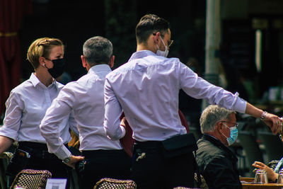 Rear view of people standing outdoors