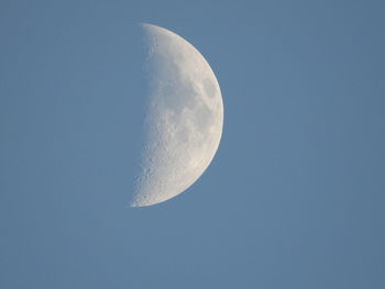 Low angle view of moon against clear blue sky