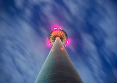 Low angle view of illuminated tower against sky in city