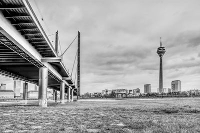 Tower bridge in city against cloudy sky