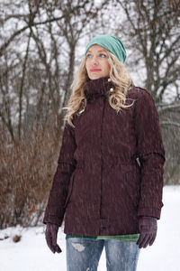 Blond woman in park during snowfall