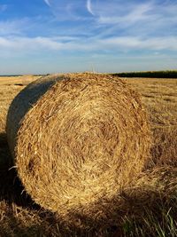 Hay bales on field against sky