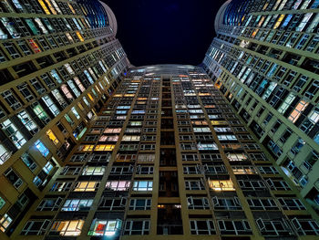 Low angle view of illuminated buildings against sky at night