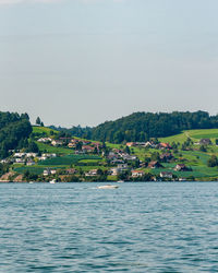 Scenic view of sea by buildings against sky