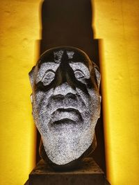 Close-up of buddha statue against yellow wall