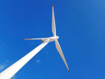 Low angle view of wind turbine against clear blue sky