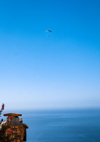 Scenic view with wing foil over sea against clear blue sky