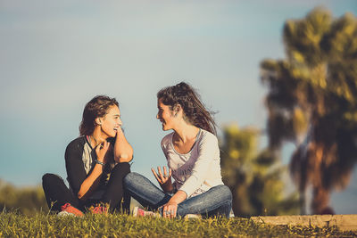 Female friends talking on field