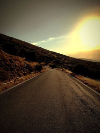 Road amidst landscape against sky during sunset