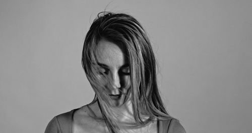 Close-up of depressed woman against white background