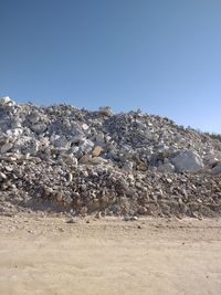 Rocks on land against clear blue sky