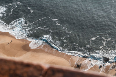 Aerial view of waves rushing towards shore