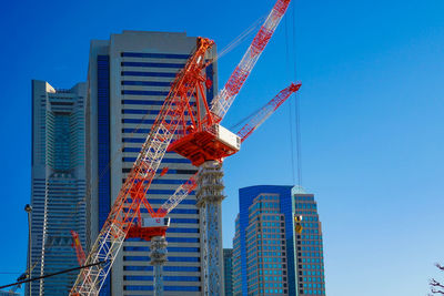 Low angle view of skyscrapers against clear blue sky