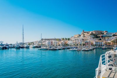 Sailboats moored at harbor