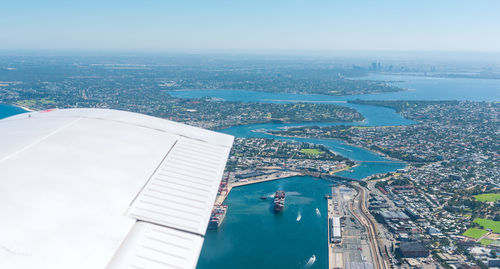 Aerial view of sea and cityscape against sky