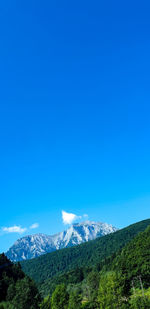 Scenic view of mountains against clear blue sky