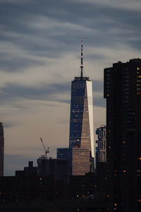 Buildings in city against cloudy sky