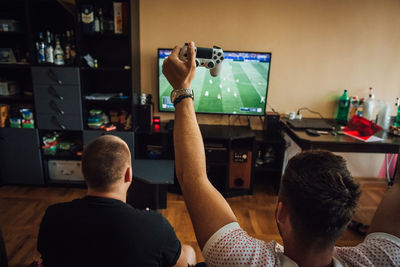 Friends playing video game at home