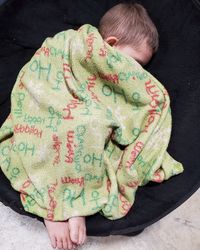 High angle view of baby sleeping on bed