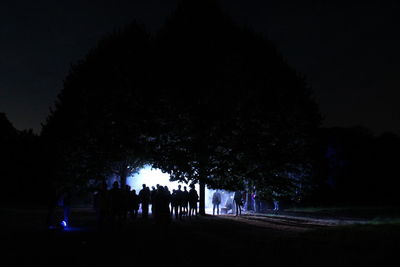 Silhouette people standing against trees