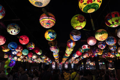 Illuminated lanterns hanging at market stall