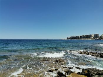 Scenic view of sea against clear blue sky