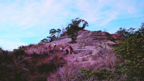 Silhouette of woman on hill against cloudy sky