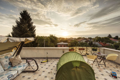 Man by swimming pool against sky during sunset