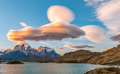 Scenic view of sea and snowcapped mountains against sky