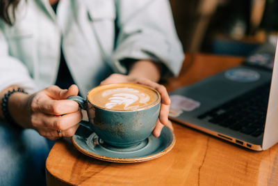 Midsection of woman using laptop on table