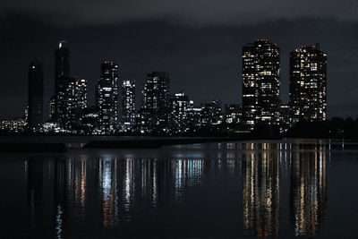 Illuminated buildings in city against sky at night