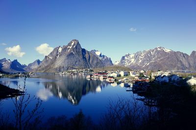 Scenic view of lake and mountains against blue sky