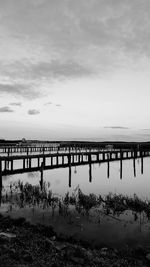 Scenic view of sea and jetty against cloudy sky