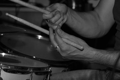 Cropped image of human hand playing drum