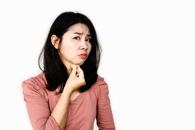 Portrait of young woman against white background
