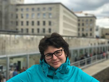 Portrait of woman against buildings in city