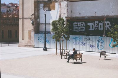 Rear view of a man with woman walking in front of building