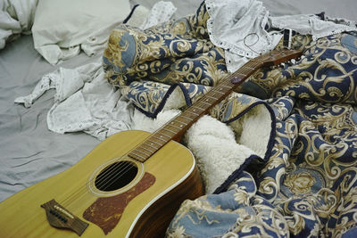 High angle view of guitar on bed