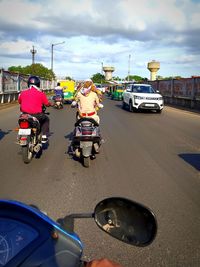 Cars on road by city against sky