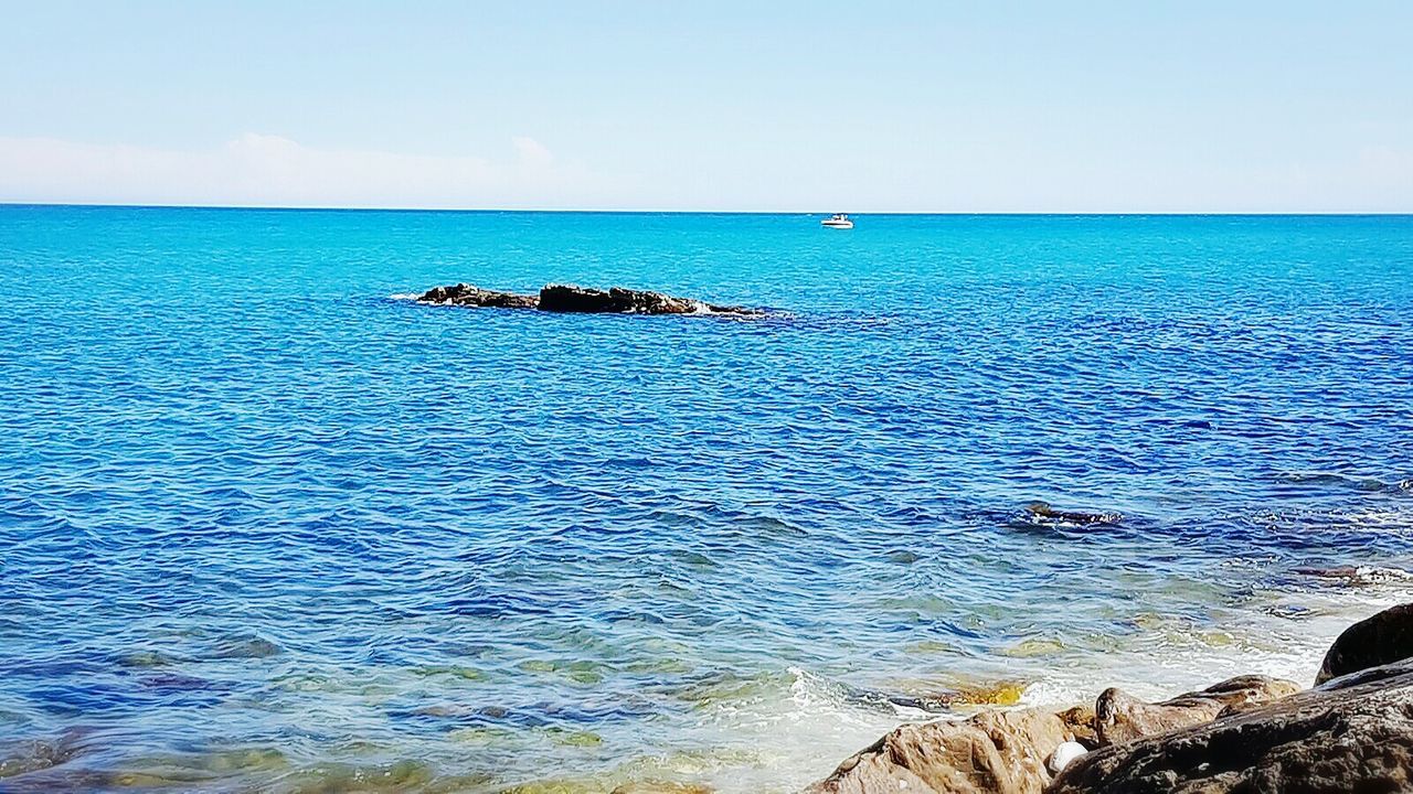 sea, horizon over water, water, scenics, tranquil scene, blue, beauty in nature, tranquility, rock - object, sky, beach, idyllic, nature, seascape, non-urban scene, outdoors, day, remote, tourism, cliff, summer, vacations, shore, cloud - sky, no people, rock formation, majestic