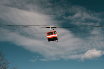 Low angle view of overhead cable car against sky