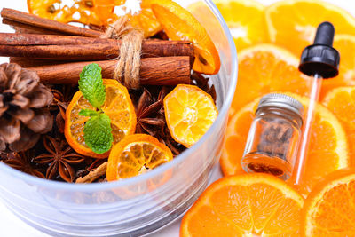 Close-up of orange slices with spice and dropper on table