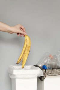 Close-up of hand holding apple against white background