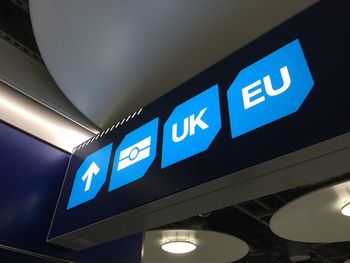 Low angle view of information sign against blue sky